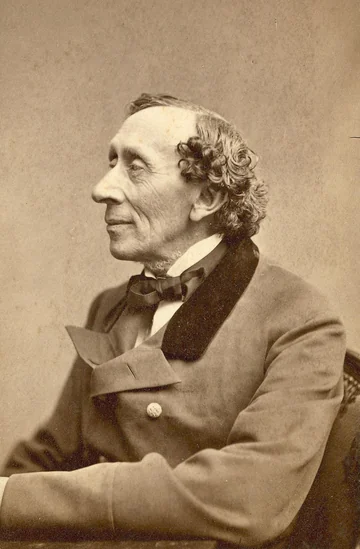 Hans Christian Andersen de perfil, sentado con una chaqueta oscura, en una fotografía de 1869.